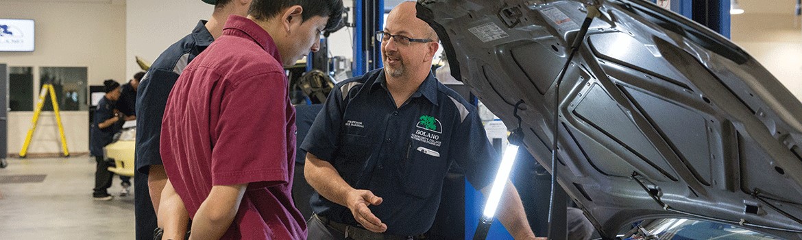 Automotive website main picture. Professor Ricky Marshall discusses auto technology with students.