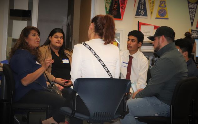 Mentor sitting with several Puentistas