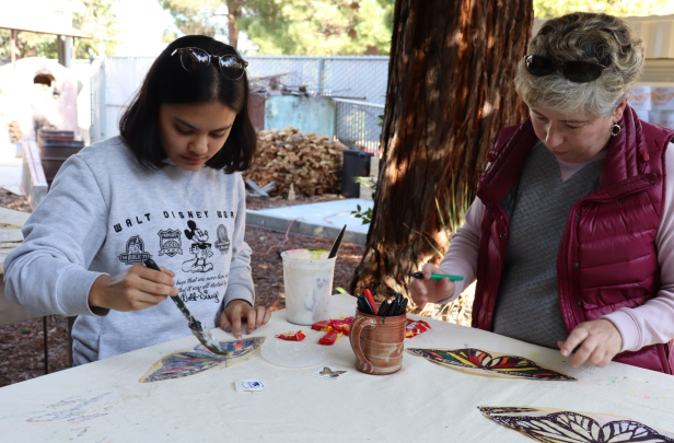 SCC student and faculty coloring butterflies for mural