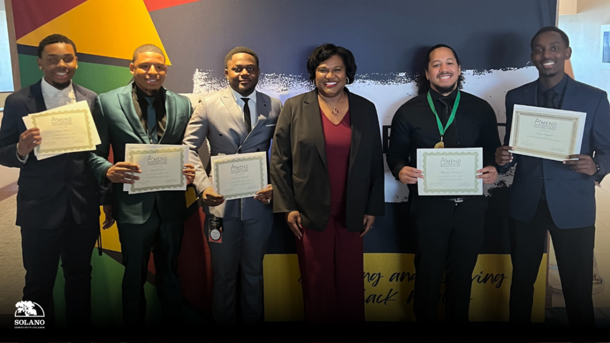 6 people stand with certificates in front of mural